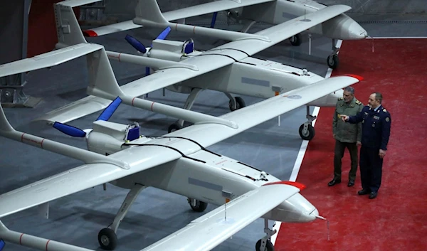 Iranian Defense Minister Gen. Aziz Nasirzadeh, right, speaks with the army commander Gen. Abdolrahim Mousavi in a ceremony to deliver domestically-built drones to the army on . (Iranian Army via AP)