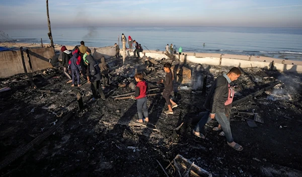 Palestinians inspect the site of an Israeli occupation forces strike early Tuesday morning in Deir al-Balah in the central Gaza Strip, Tuesday, January 14, 2025 (AP)