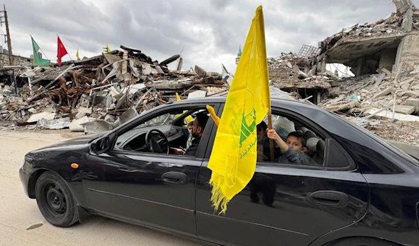 A boy holds a Hezbollah flag following a ceasefire between the Israeli occupation and Hezbollah on Nov. 28, 2024, in Nabatiyeh, southern Lebanon (AP)