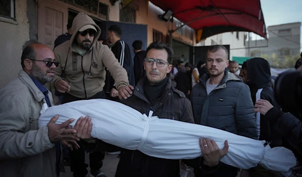 Waleed Shaqoura carries the body of his nephew, Mohammad Shaqoura, 7, who was killed in the Israeli bombardment of the Gaza Strip, during his funeral in Deir al-Balah, Wednesday, Jan. 15, 2025. (AP)