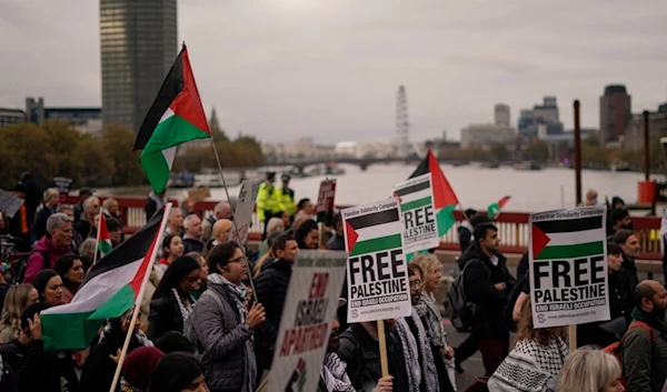 Protesters hold flags and placards during a march in support of the Palestinian people in Gaza, in London, Saturday, Nov. 2, 2024. (AP)