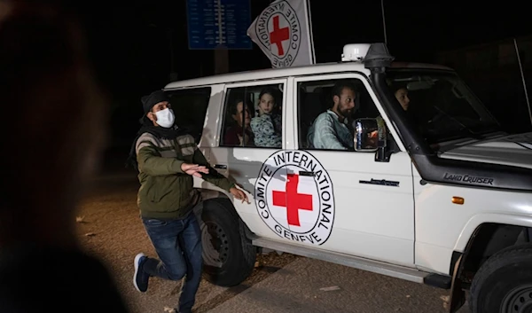 A Red Cross vehicle carrying Israeli captives drives by at the Gaza Strip crossing into Egypt in Rafah on Nov. 25, 2023 (AP)