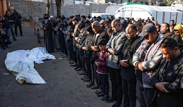 Mourners recite a prayer over the bodies of four people killed in an Israeli strike north of Khan Younis in the southern Gaza Strip, in the yard of the Nasser hospital on January 18, 2025 (AFP)