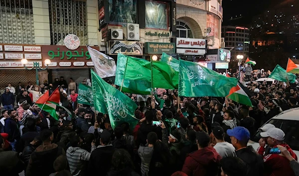 Palestinians wave Hamas flags as they celebrate the release of Palestinian prisoners in Nablus in the West Bank, Nov. 24, 2023. (AP)