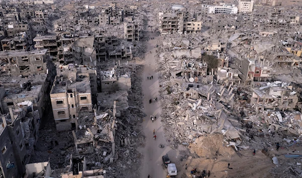 An aerial photograph taken by a drone shows Palestinians walking through the destruction caused by the Israeli air and ground offensive, in Rafah, Gaza Strip, on January 21, 2025. (AP)