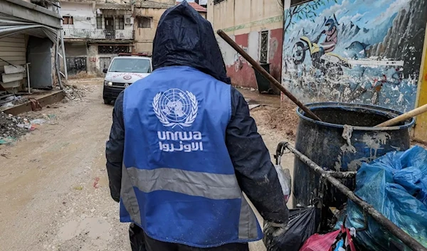 An UNRWA worker in Jenin collects rubbish from the streets of a refugee camp, January 30, 2024. (AFP)