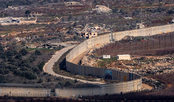 A wall marks the Israeli-Lebanese border near the village of Odaisseh in southern Lebanon, as seen from northern occupied Palestine, on January 23, 2025. (AP)