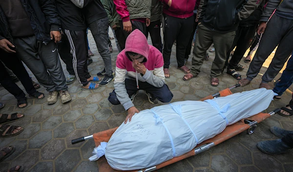 A man mourns over the body of a Palestinian man killed during an Israeli army strike in Deir al-Balah in the central Gaza Strip, on January 2, 2025. (AP)