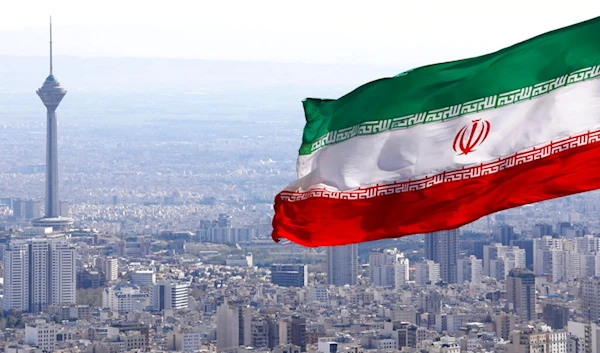 In this March 31, 2020, file photo, Iran's national flag waves as Milad telecommunications tower and buildings are seen in Tehran, Iran. (AP)