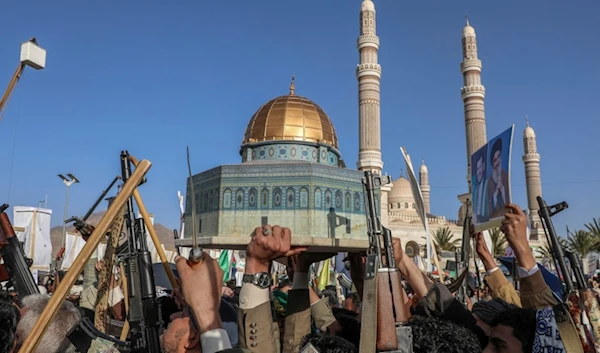 Yemenis hold a replica of Al-Aqsa Mosque and raise their machine guns during a pro-Palestine rally in Sanaa, Yemen, Friday, Dec. 27, 2024. (AP)