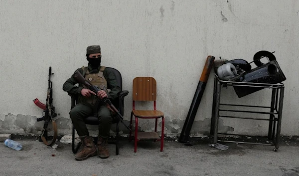 A member of the security forces of the newly formed Syrian government looks on as members of Bashar al-Assad’s army line up to register as part of ‘identification and reconciliation’ process in Damascus, Syria, December 30,2024. (AP)