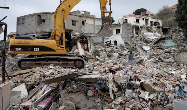 Rescuers use an excavator as they search for dead bodies through the rubble of a destroyed house, following a ceasefire between the Israeli occupation and Lebanon that went into effect on Wednesday, Nov. 27, 2024, in Ainata, south Lebanon (AP)