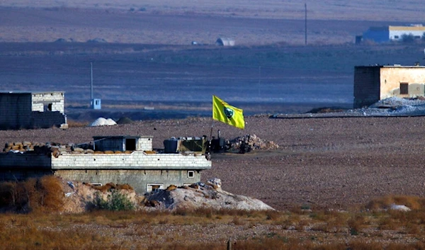 A flag of the Kurdish People's Protection Units, or YPG, flies on a building in Akcakale, Sanliurfa province, southeastern Turkey, Wednesday, Oct. 9, 2019 (AP)